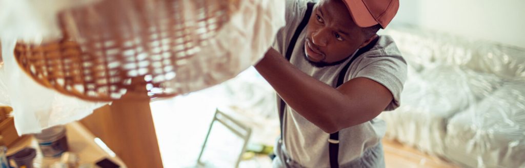 Close up of a young man renovating and painting the house